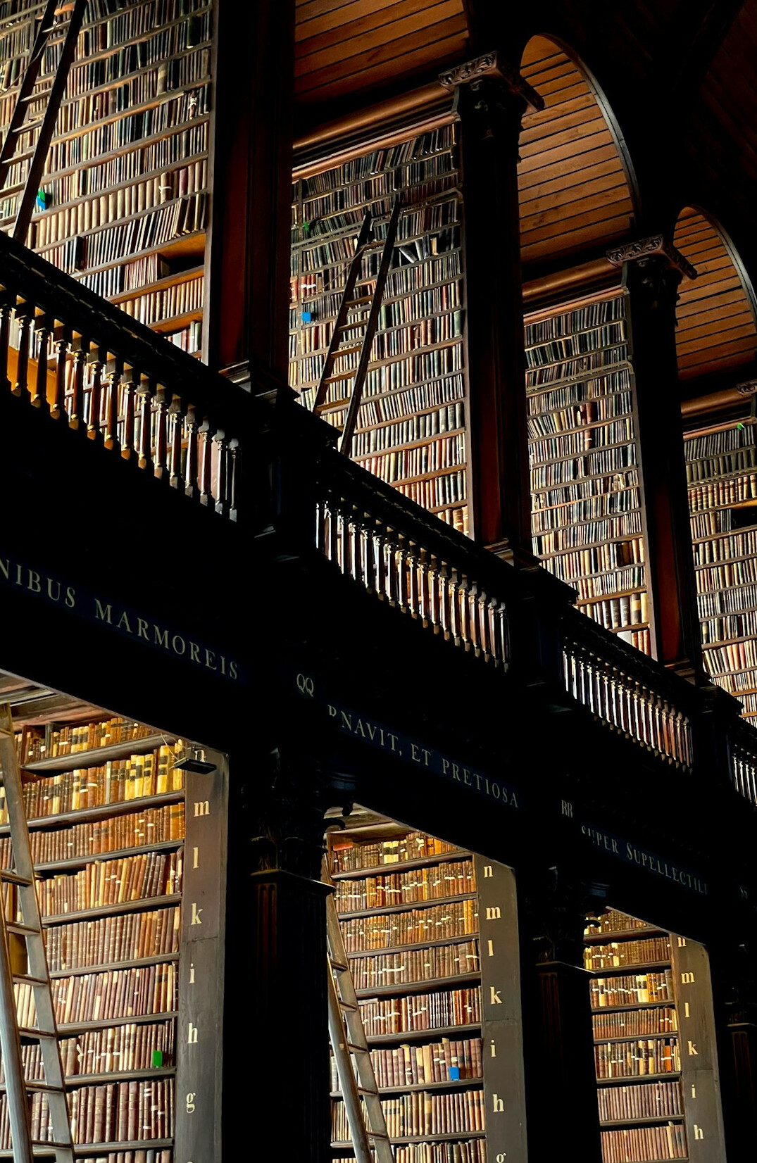 Old library with tall wooden shelves full of books