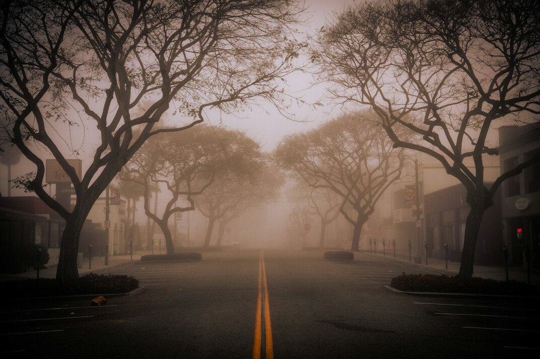 Quiet old city street in soft morning fog